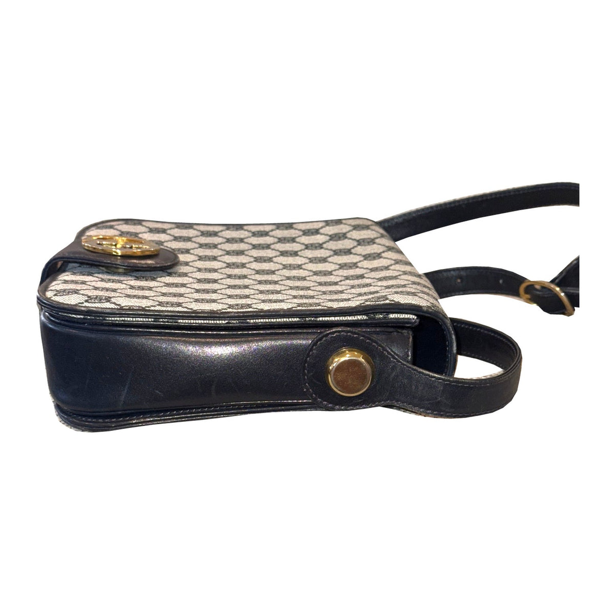 Side view of the Gucci shoulder bag, showing navy trim, round gold-tone strap attachment and edge wear.