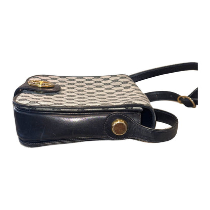 Side view of the Gucci shoulder bag, showing navy trim, round gold-tone strap attachment and edge wear.
