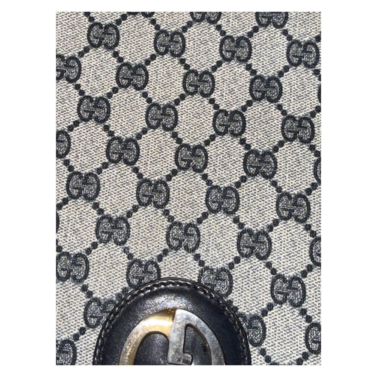 Close-up of the Gucci bag’s beige and navy GG monogram pattern above the clasp.