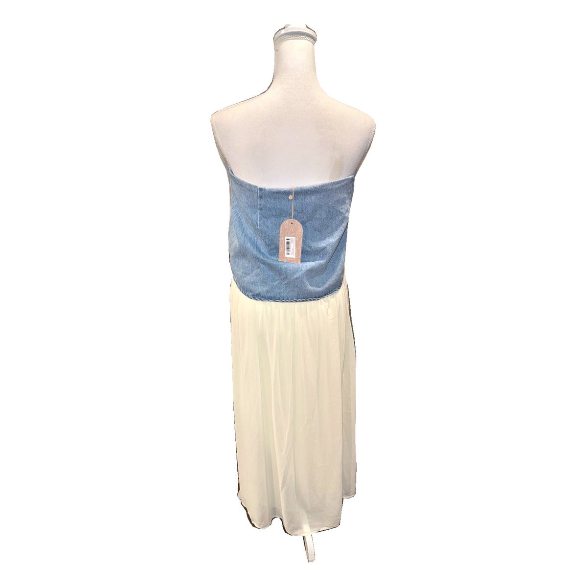 Back of the MESHKI Tully denim and chiffon maxi skirt displayed on a mannequin, with hangtag attached.