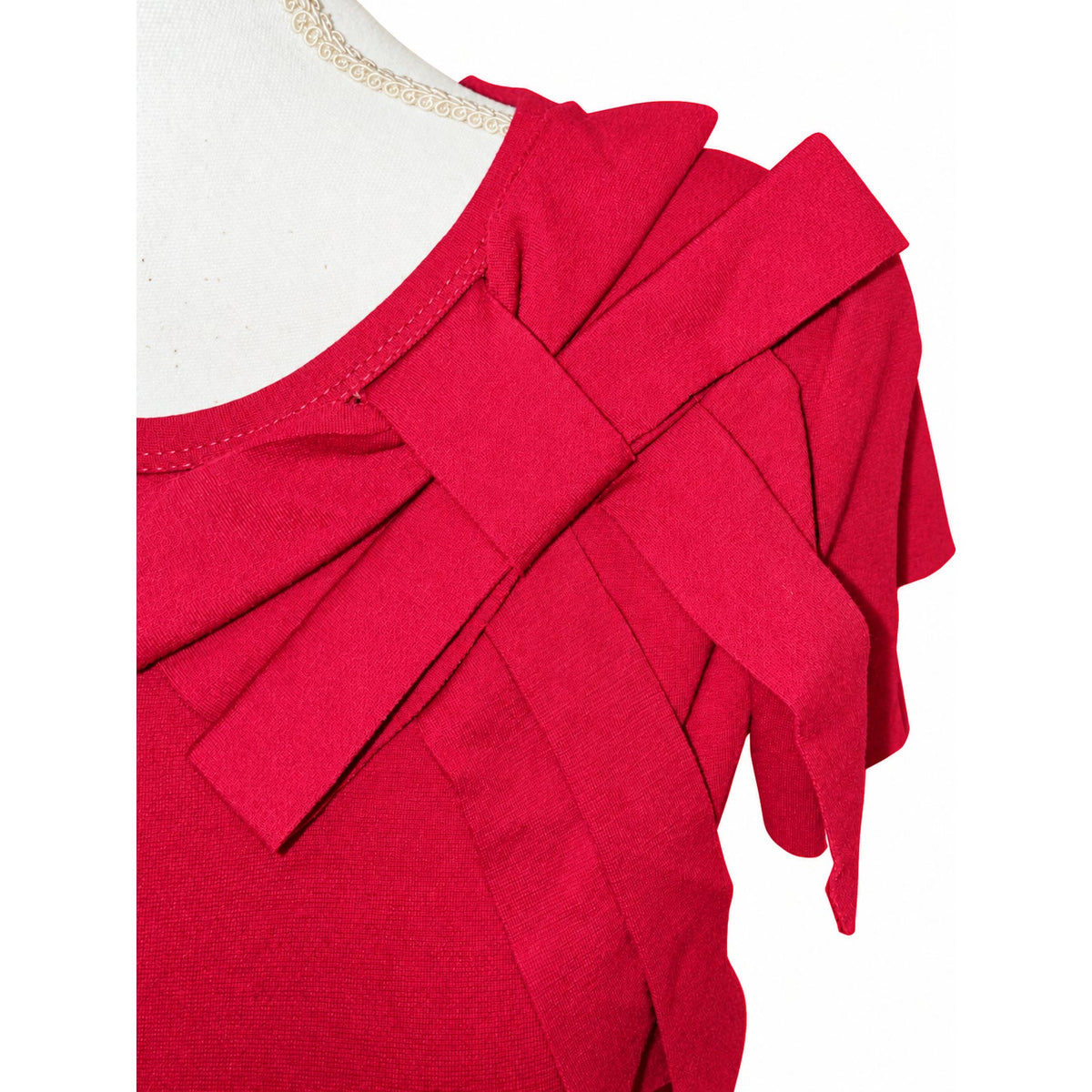 Close-up of the layered bow and round neckline on the reddish-pink RED Valentino dress.