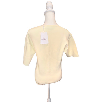 Back of the ivory ANINE BING Damion short-sleeve sweater with hangtag attached.