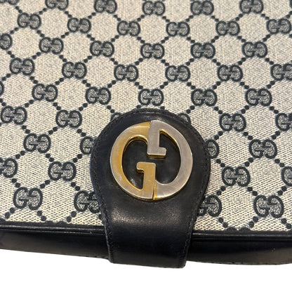 Close-up of the Gucci bag’s gold- and silver-tone G clasp with visible surface wear against the GG monogram.