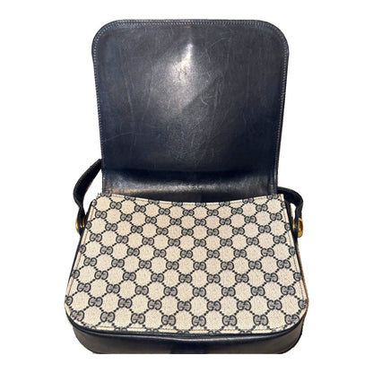 Gucci shoulder bag with flap open, showing the navy flap lining and GG monogram front panel.