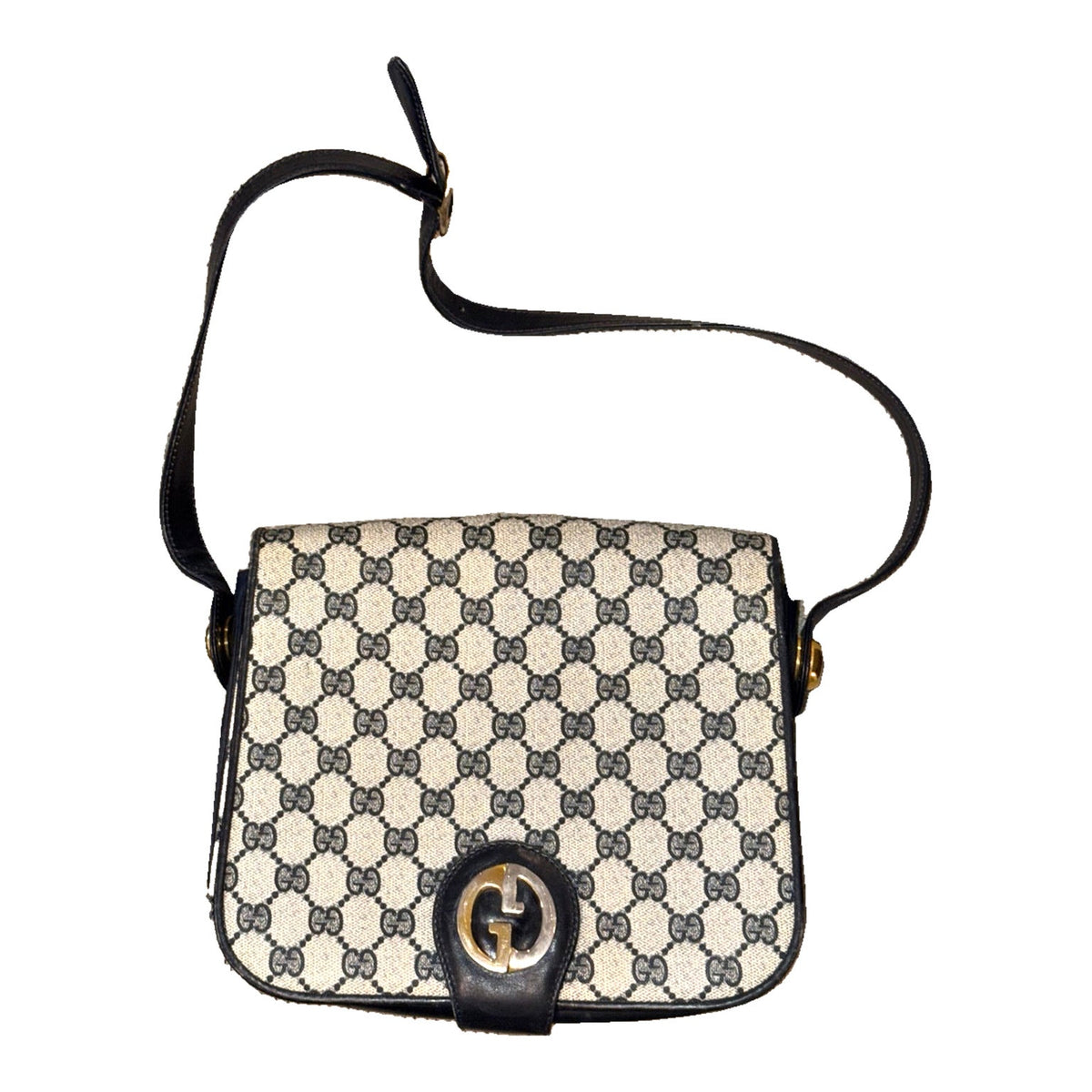 Front of the beige Gucci GG monogram shoulder bag with navy trim, adjustable strap and two-tone G clasp.