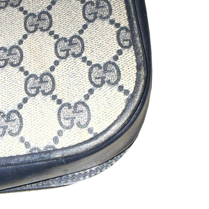 Close-up of a lower corner of the Gucci bag, showing GG monogram fabric and worn navy piping.
